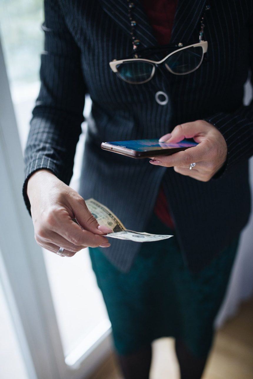 A hand holds a smartphone displaying a crypto wallet app with account balances.
