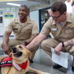 A therapy dog with its handlers in a clinical facility