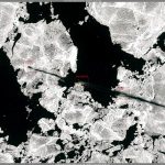 A cargo vessel navigating through icy Arctic waters