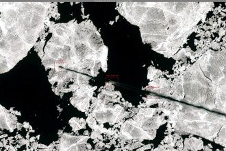 A cargo vessel navigating through icy Arctic waters